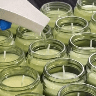 Hand pouring natural plant wax candles at Heaven Scent workshop